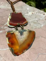 Collar con dije de ágata verde con engarce dorado y cordón de cuero marrón.