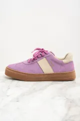 Zapatilla urbana de gamuza color lila con detalles en beige y suela marrón.