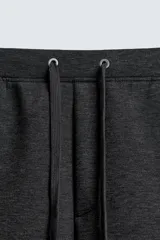 Pantalón de corte wide fit confeccionado en tejido técnico con efecto neopreno. Presenta cintura elástica ajustable con cordón, perneras anchas con costura frontal, bolsillos laterales y bolsillos traseros de plastrón.