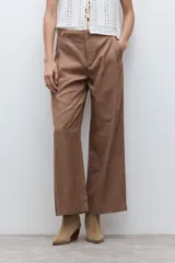 Pantalón de corte sastrero y pierna ancha, confeccionado en lyocell. Presenta pinzas en la cintura, cierre frontal con botón y bolsillos laterales. Incluye un cinturón fino de cuero con hebilla metálica.