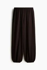 Pantalón globo de corte holgado en punto con textura, color marrón oscuro, con cintura elástica y bajos elásticos.
