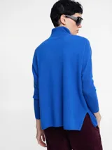 Sweater de cuello alto en punto acanalado, color verde menta, con mangas ajustadas y cuerpo amplio y suelto.