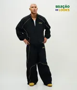 Pantalón deportivo de microfibra color negro, con corte holgado y diseño de piping contrastante en color amarillo. Cuenta con cintura elástica con cordón de ajuste, bolsillos laterales y logo bordado.