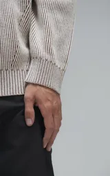 Sweater de punto con diseño de rayas verticales en tonos beige y marrón, cuello redondo y corte oversize.