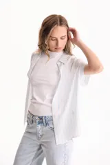 Camisa de viscosa con patrón de rayas verticales en tonos beige y blanco, cuello camisero, manga corta y cierre frontal con botones.