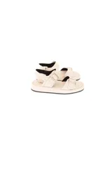 Sandalias planas color off-white, con múltiples tiras ajustables con hebillas metálicas plateadas y plataforma baja.