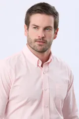Camisa Oxford lisa de color celeste, con cuello abotonado, manga larga, cierre frontal de botones y un bolsillo aplicado en el pecho con detalle bordado.