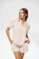 Camisa de lino a rayas verticales rojas y blancas, con cuello mao, escote en V, mangas cortas abullonadas y botones de nácar ocultos.