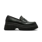 Zapato tipo mocasín de plataforma con suela track dentada, color negro, con detalle de tachas metálicas plateadas en el empeine.