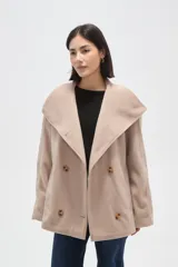 Tapado corto de paño en color beige, con cuello solapa amplio y cierre frontal cruzado con doble botonadura. Presenta mangas largas y bolsillos laterales integrados.