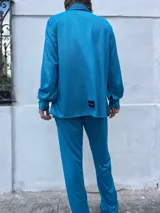 Camisa turquesa de manga larga con botones.