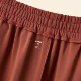 Pantalón de jogging de corte wide leg, color marrón, con cintura elástica y cordón ajustable. Presenta bolsillos laterales y un diseño holgado.