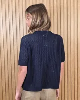 Cardigan calado de manga corta, tejido en punto con cierre frontal de botones y cuello redondo.
