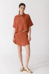 Minifalda roja de lino con botones de madera en el frente.