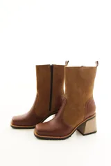 Bota de caña media combinada en cuero liso y descarne color marrón, con punta cuadrada, cierre lateral y taco ancho de madera.