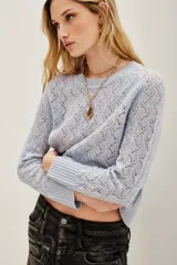Sweater de punto calado con diseño de ondas, cuello redondo y mangas largas con puños acanalados.