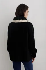 Camisa de paño de lana, color negro, con cuello tejido en contraste y cierre frontal de botones claros. Presenta bolsillos frontales y diseño de corte recto.