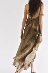 Top de cuello halter con tiras cruzadas para atar al cuello, hombros descubiertos y bajo asimétrico con caída drapeada y textura rústica con estampado sutil.