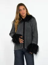 Saco de punto acanalado en color gris oscuro, con cierre frontal y detalles de piel sintética negra en el cuello y los puños.