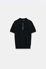 Top negro de punto fino con cuello polo, manga corta, cierre frontal de botones y un bolsillo de parche en el pecho.