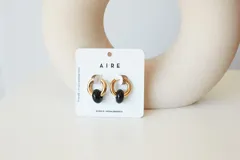 Aros dorados con dije circular de piedra natural negra.