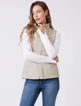 Chaleco capitoneado color verde oliva, con cuello alto, cierre frontal completo y bolsillos laterales. El interior está completamente forrado en símil piel para mayor calidez.