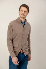 Sweater de lana lambswool color gris, con cuello alto, cierre frontal de botones y dos bolsillos delanteros tipo parche.