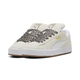 Championes Puma Suede XL Wild de mujer, en color gris claro con franja lateral blanca y suela de goma marrón. Presentan cordones anchos con estampado animal print tipo leopardo y detalles de la marca en dorado metalizado en el lateral.