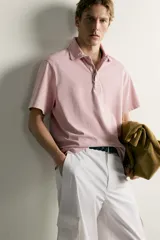 Polo de corte regular fit en color rosado con efecto lavado. Presenta cuello solapa, cierre frontal de botones y mangas cortas con acabados en rib.