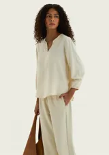 Blusa de viscosa color marrón, con escote en V profundo, mangas tres cuartos abullonadas y puños elásticos.