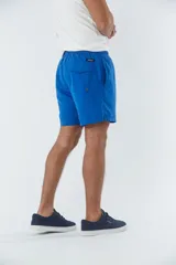 Short de baño liso con cintura elástica y cordón de ajuste. Cuenta con dos bolsillos laterales, un bolsillo posterior y un aplique de logo en goma en la pierna.