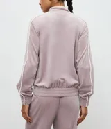 Campera deportiva de plush color negro con cuello alto, cierre frontal por cremallera, bolsillos laterales y detalle de piping blanco contrastante en mangas y bolsillos.