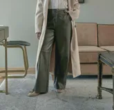 Pantalón de cuerina verde oliva, de corte recto y tiro alto, con cierre y broche escondido.