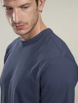 Remera de algodón color azul marino, con estampa gráfica en la espalda que representa un paisaje de dunas con un círculo superior y texto de la marca Benson & Thomas.