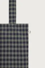 Bolso tipo shopper de la colección Benito Antonio x Zara, confeccionado en tejido con estampado a cuadros en tonos marrones y blancos. Cuenta con compartimento principal sin cierre, doble asa de mano y un pequeño bordado distintivo en la parte inferior.