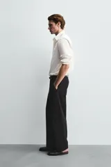 Pantalón de corte balloon fit confeccionado en una mezcla de lyocell y algodón. Presenta cierre frontal con cremallera y botón, bolsillos laterales y bolsillos traseros de vivo.