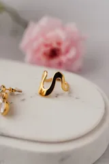 Anillo dorado con diseño ondulado y minimalista, fabricado en acero quirúrgico con baño de oro.