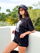 Remerón oversize de algodón color negro, con cuello redondo y manga corta. Presenta una estampa fotográfica en blanco y negro en el frente.