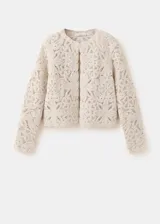 Chaqueta de punto grueso color beige con diseño de encaje en relieve, cuello redondo y cierre frontal.