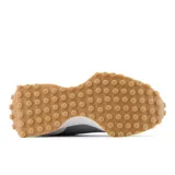 Championes New Balance modelo 327 para mujer, color gris claro y gris medio, con logo 'N' superpuesto en gamuza. Presentan una entresuela blanca y suela exterior de goma color caramelo con tacos prominentes.