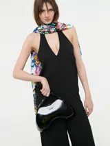 Mono color beige con escote halter, corte holgado, cinturón dorado y pantalones palazzo.