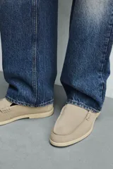 Mocasín casual de hombre confeccionado en piel con acabado serraje en color beige, con detalle de bordón en el empeine y suela fina al tono.