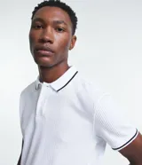 Polo de hombre marca Marfinno, confeccionada en tejido de media malla con textura rayada. Presenta cuello polo con botones y mangas cortas con terminaciones en rib con detalles contrastantes.