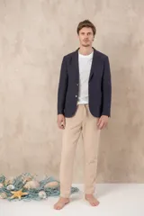 Pantalón de ramio y algodón color beige, con cintura elástica ajustable con cordón y ruedo con dobladillo.