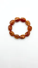Pulsera elástica con cuentas asimétricas de acrílico con efecto marmolado en tonos marrones y caramelo.