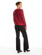 Cardigan tejido con diseño de cuadrille en contraste rojo y negro, escote redondo y cierre frontal con botones metálicos. Presenta bolsillos delanteros y terminaciones en rib en cuello, puños y ruedo.