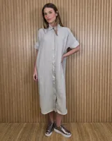 Vestido midi estilo túnica color celeste con rayas verticales blancas, cuello camisero, mangas cortas y cierre frontal con botones ocultos.