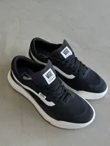 Championes Vans Ultrarange 2.0 RW, color negro con franja lateral blanca, entresuela blanca y suela de goma marrón.
