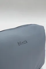 Neceser gris con el logo de la marca en negro. Cuenta con un compartimento principal con cierre, un bolsillo lateral para accesorios y un bolsillo interior con cierre. Tiene una capacidad de 5.77 litros.