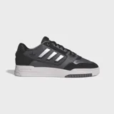 Championes Adidas Drop Step Low 2.0, color negro con detalles plateados y suela blanca. Diseño de caña baja inspirado en el básquet, con exterior de gamuza y material sintético.